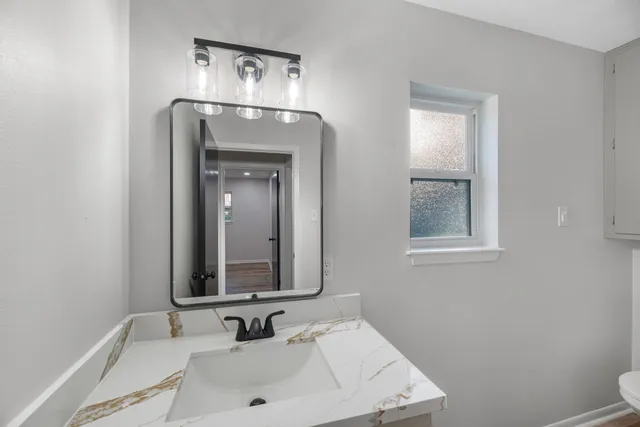 a bathroom with a white toilet and a sink
