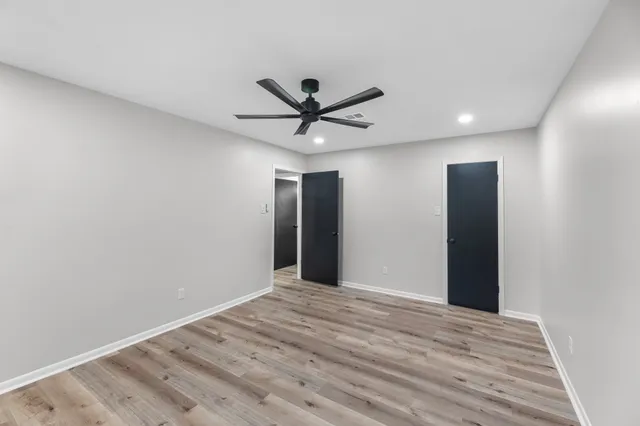 a view of a big room with wooden floor and a ceiling fan