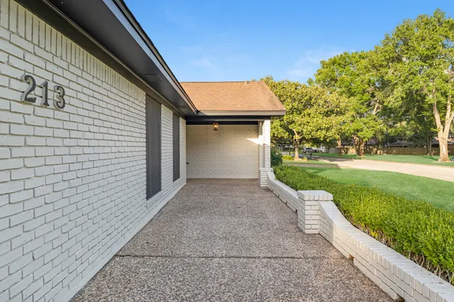 a front view of a house with a yard and potted plants