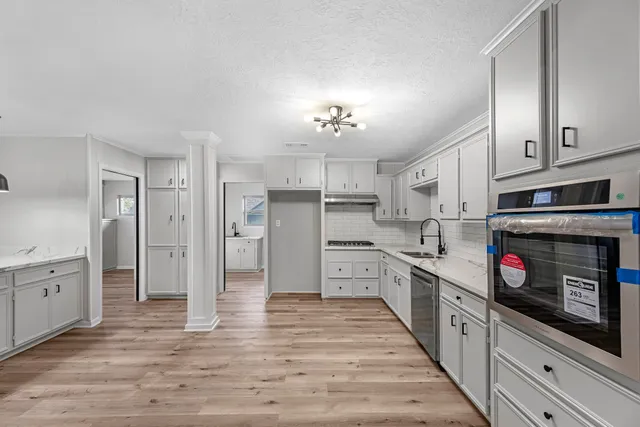 a kitchen with stainless steel appliances granite countertop a refrigerator and a stove top oven