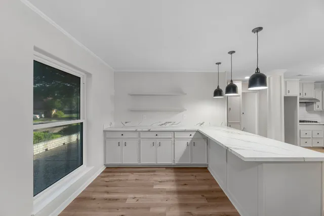 a kitchen with white cabinets and sink