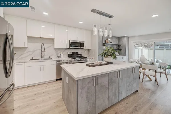 a kitchen with a sink a counter top space stainless steel appliances and cabinets