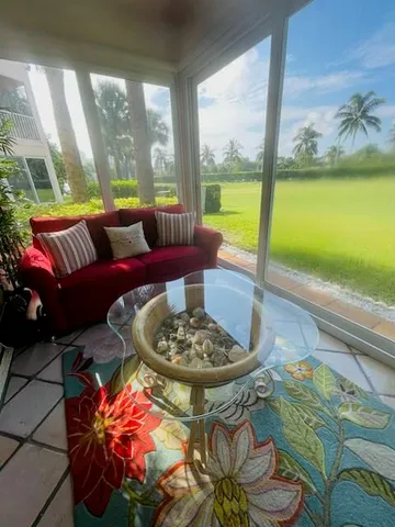 a living room with furniture and a floor to ceiling window