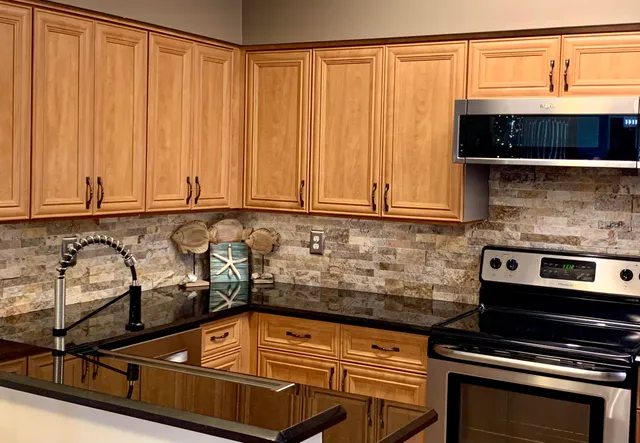 a kitchen with granite countertop a stove and cabinets