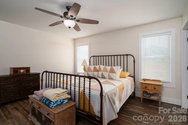 a bedroom with bed and wooden floor