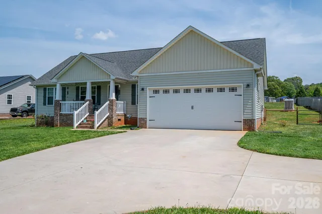 a kitchen with kitchen island granite countertop a refrigerator a sink dishwasher a stove and white cabinets with wooden floor