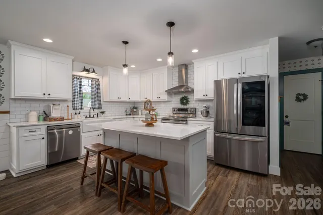 a kitchen with a sink a stove a refrigerator and white cabinets