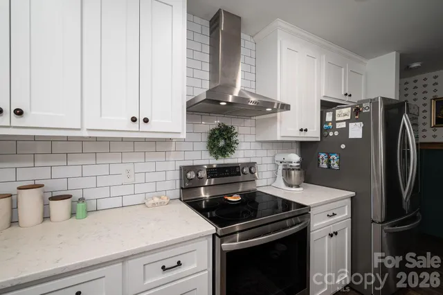 a kitchen with refrigerator a stove and cabinets