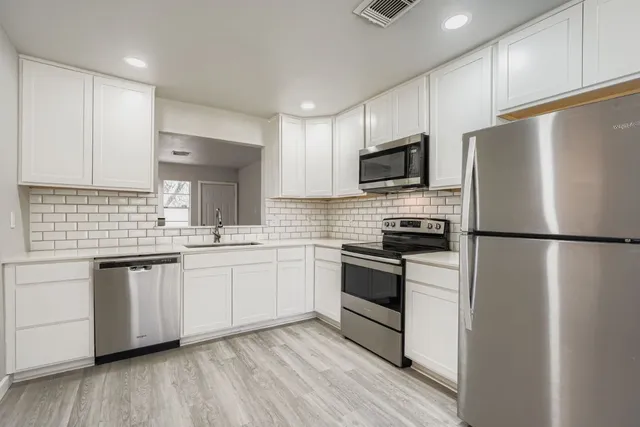 a kitchen with stainless steel appliances a refrigerator sink and microwave