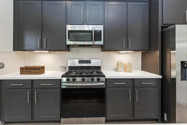a kitchen with stainless steel appliances granite countertop a stove and a microwave