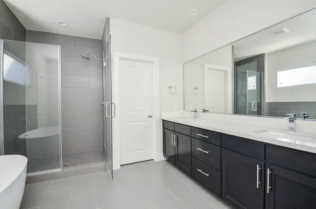 a bathroom with a double vanity sink toilet and shower