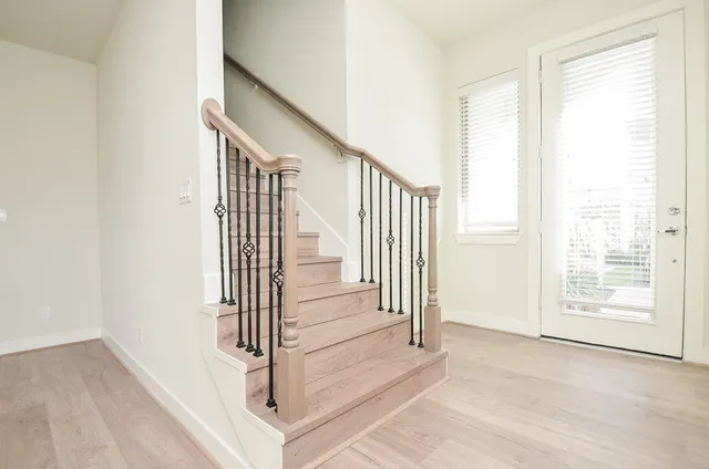 a view of a hallway with wooden floor and entryway