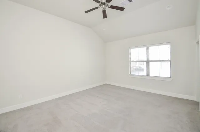 an empty room with a window and a fan