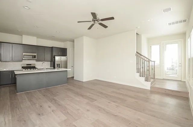 a view of kitchen with stainless steel appliances cabinets and wooden floor