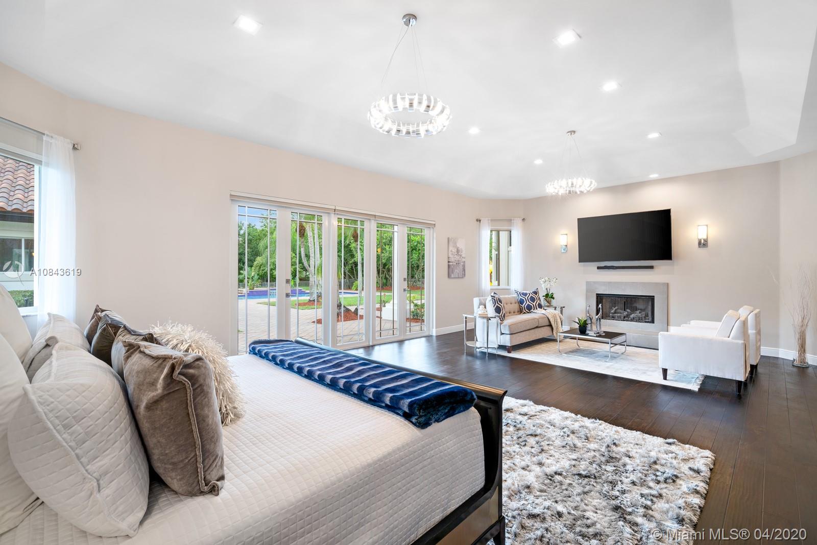 2725 Windmill Ranch Road Weston, FL 33331 - Photo 8 of 42 Spacious Masted suite, with double door entry and grand foyer, sitting area with fireplace, French door to private patio, overlooking oversize heated pool/spa and lake view. 3 walk-in closets to allow ample space and storage.