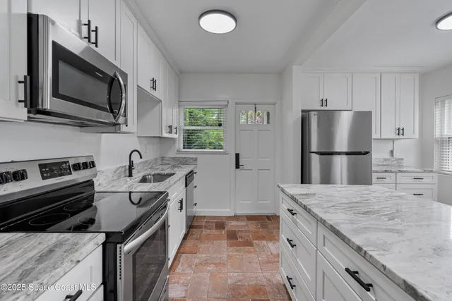 a kitchen with granite countertop a sink stove and cabinets