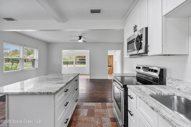 a kitchen with granite countertop cabinets and refrigerator