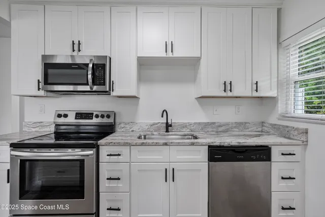 a kitchen with cabinets and steel appliances