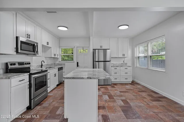 a view of a livingroom with wooden floor and a ceiling fan