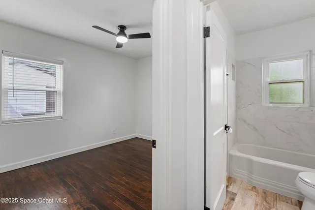 a bathroom with a granite countertop sink a toilet and a bathtub
