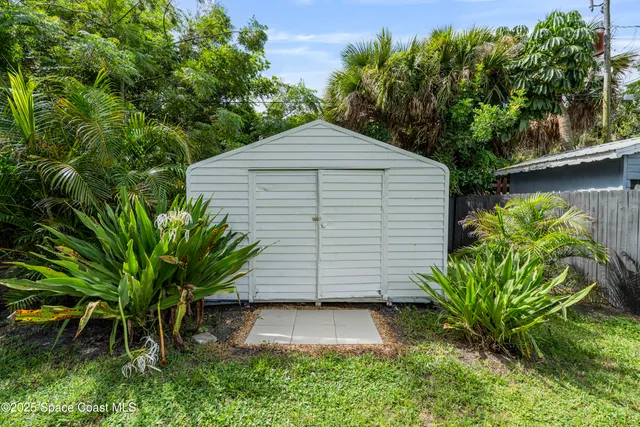 a view of a house with backyard and a tree