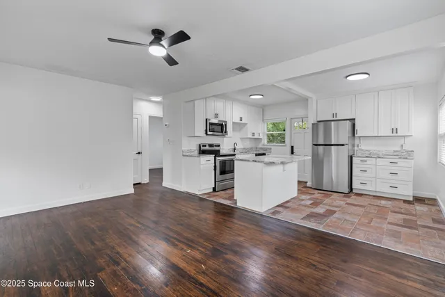 a view of kitchen with sink microwave refrigerator and stove