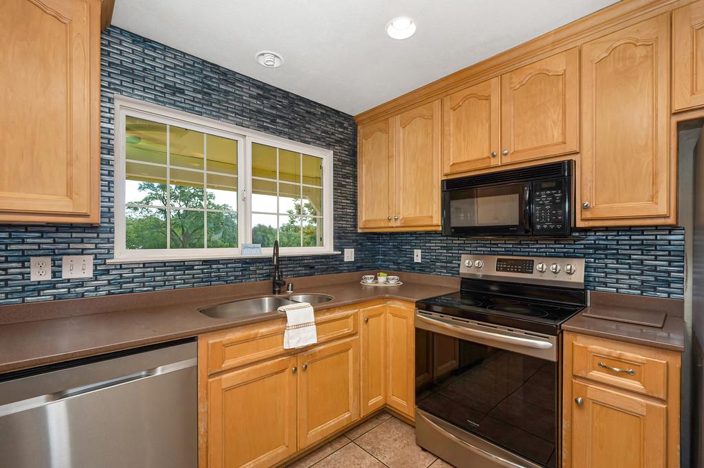 6181 Lambert Lane El Dorado, CA 95623 - Photo 32 of 68 kitchen featuring stainless steel appliances, light tile patterned floors, and tasteful backsplash