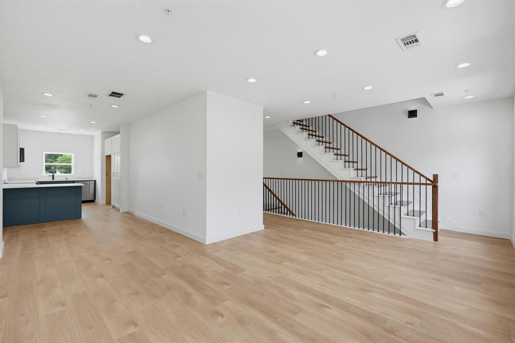 508 South O Connor Road Irving, TX 75060 - Photo 3 of 21 Open-concept living space with wood-finish flooring, recessed lighting, and a modern staircase featuring dark metal balusters and wood handrails