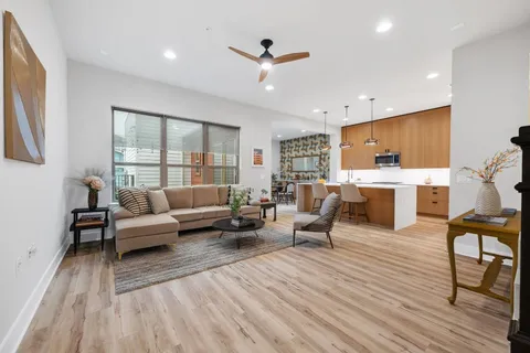 a living room with furniture and a wooden floor