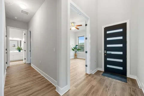 a living room with furniture kitchen view and a large window
