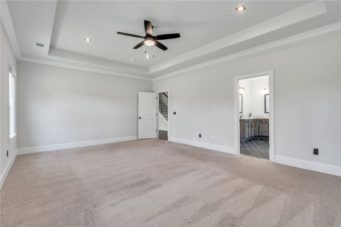 226 Holly Br Road Piedmont, SC 29673 - Photo 19 of 44 A spacious primary bedroom features soft carpeting, recessed lighting, and a ceiling fan for ultimate comfort.