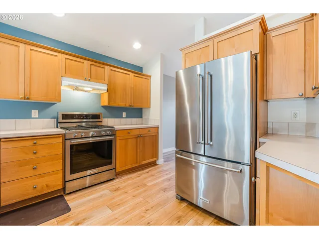 a kitchen with stainless steel appliances a refrigerator sink and microwave