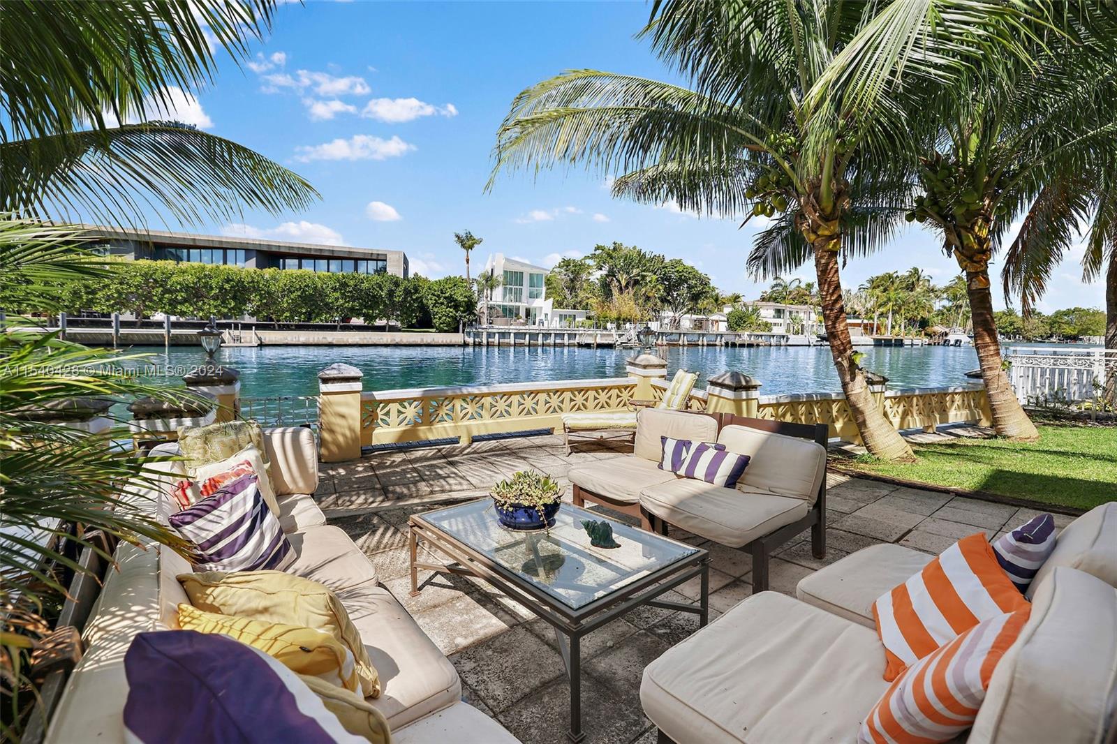 4812 Pine Tree Drive, Unit 207 Miami Beach, FL 33140 - Photo 15 of 23 a view of a patio with couches chairs and a floor to ceiling window next to a yard