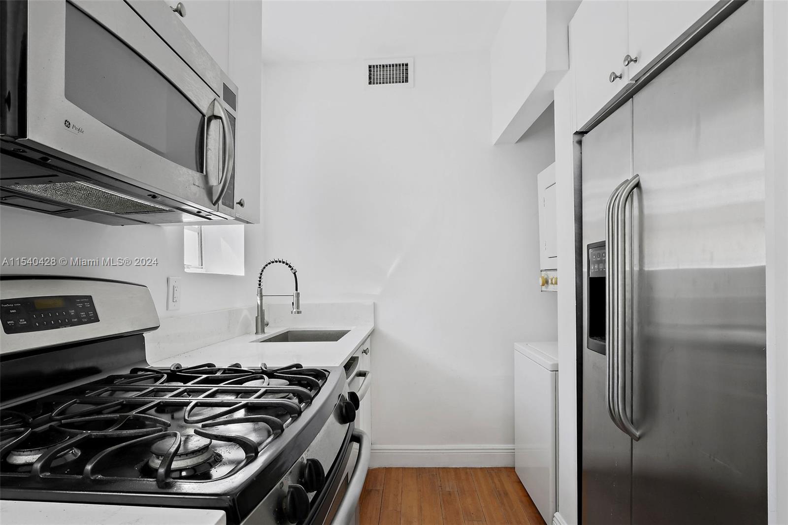4812 Pine Tree Drive, Unit 207 Miami Beach, FL 33140 - Photo 6 of 23 a kitchen with stainless steel appliances granite countertop a stove and a refrigerator