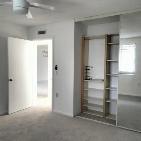 a view of an empty room with cabinet and stairs