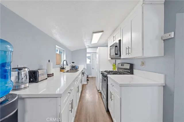 a kitchen with stainless steel appliances a sink stove and refrigerator