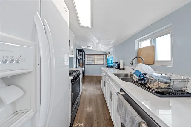 a kitchen with granite countertop a sink stove and cabinets