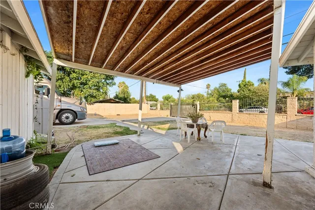 a view of a patio with table and chairs potted plants with floor to ceiling window