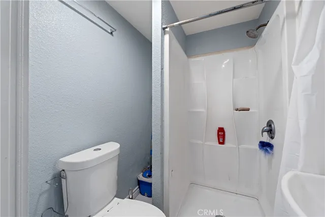 a white toilet sitting next to a white sink