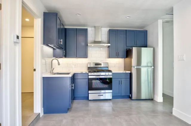 a kitchen with stainless steel appliances granite countertop a refrigerator and a stove