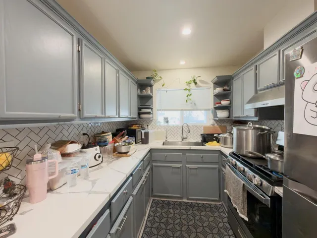 a kitchen with stainless steel appliances a sink stove and cabinets