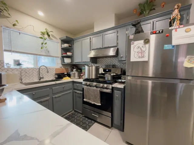 a kitchen with stainless steel appliances granite countertop a refrigerator sink and stove