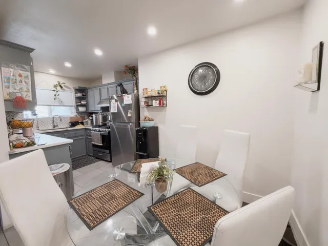 a living room with furniture a clock on wall and a table