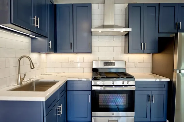 a kitchen with granite countertop a sink stainless steel appliances and cabinets