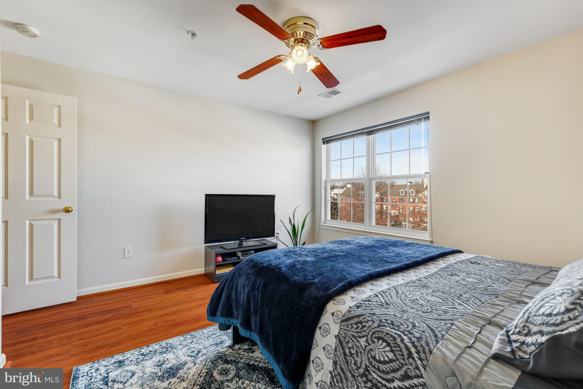 521 Constellation Square Southeast, Unit J Leesburg, VA 20175 - Photo 27 of 37 a bedroom with a bed and a flat screen tv