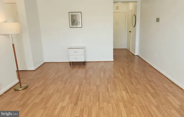 an empty room with wooden floor and a sink