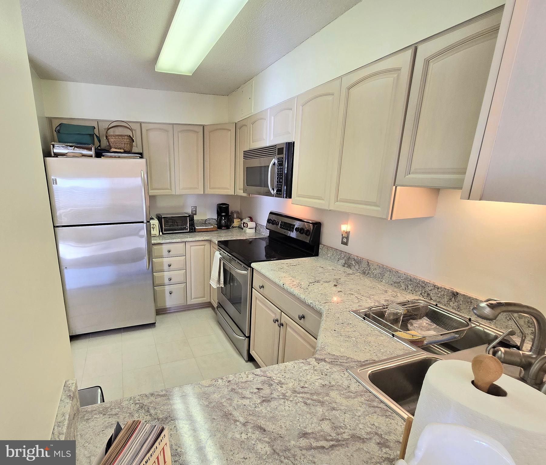 2111 Wisconsin Avenue Northwest, Unit 401 Washington, DC 20007 - Photo 4 of 16 a kitchen with a stove a sink and a refrigerator