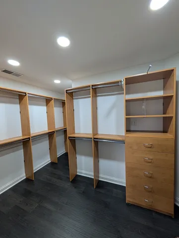 an empty room with wooden floor ceiling fan and windows