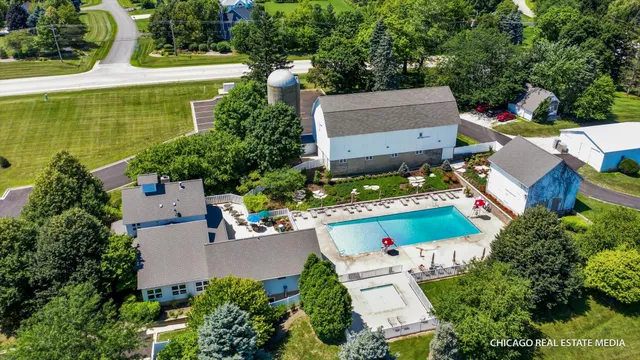 an aerial view of residential houses with outdoor space and lake view