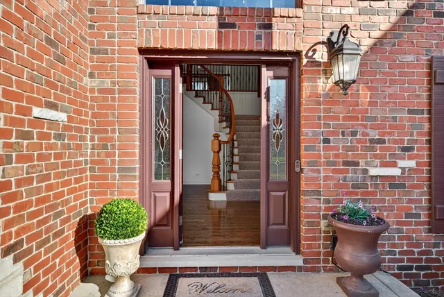 a view of staircase with lots of frames on wall and wooden floor